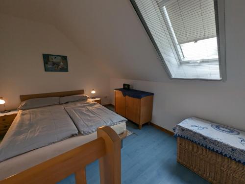 a bedroom with a large bed and a window at FeWo Deichblick - Javenloch in Wittmund