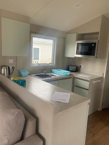 a small kitchen with a sink and a counter top at Spruce Ridge 86, Blue Dolphin in Gristhorpe