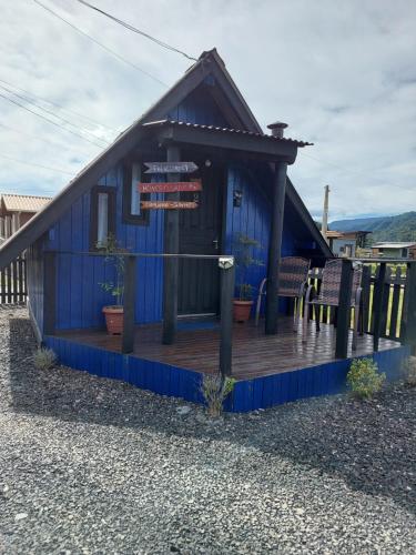 a blue building with a deck with a sign on it at Chalé Brisa do Valle in Urubici