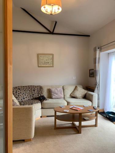 a living room with a couch and a coffee table at The Barn at White Rose Cottage in Towcester