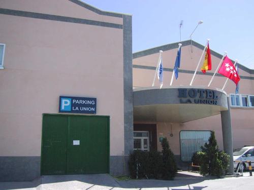 um hotel com bandeiras em frente a um edifício em Hotel La Union em Humanes de Madrid