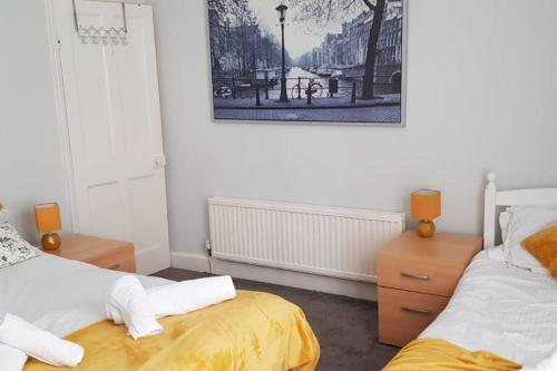 a bedroom with two beds and a picture on the wall at Matlock House Great 2 Bedroom House NG4 Postcode Parking Sleeps 6 in Nottingham