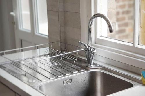 a kitchen sink with a dish drying rack next to a window at Matlock House Great 2 Bedroom House NG4 Postcode Parking Sleeps 6 in Nottingham