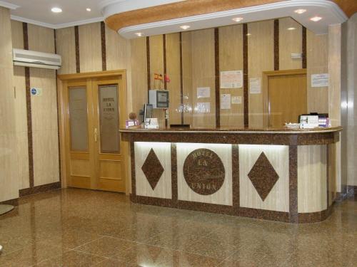 a lobby with a reception counter in a building at Hotel La Union in Humanes de Madrid