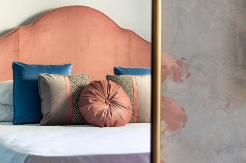 a bed with a head board with pillows on it at Santarosa Rooms in Florence
