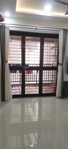 Habitación con una gran puerta de cristal con ventanas. en Hari om phase 2 en Nashik