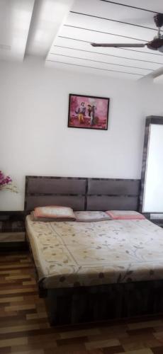 1 cama en una habitación con una foto en la pared en Hari om phase 2 en Nashik
