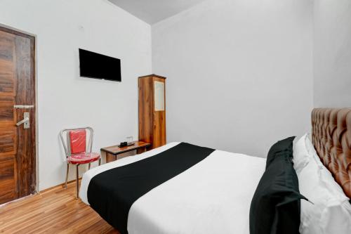 OYO Flagship Hotel Blue Moon في باتنا: غرفة نوم بسرير وكرسي احمر