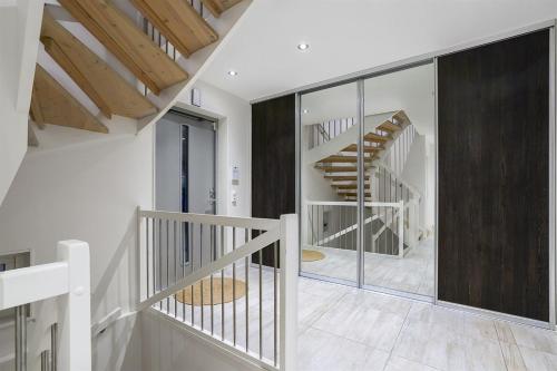una escalera blanca en una casa con paredes de cristal en living with the host and the dog Comfortable double room in a house in Lillestrøm en Lillestrøm