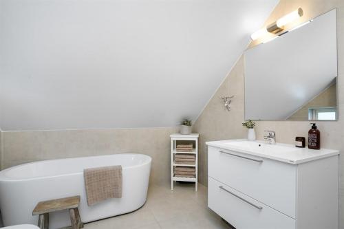 uma casa de banho com uma banheira branca e um lavatório. em living with the host and the dog Comfortable double room in a house in Lillestrøm em Lillestrom