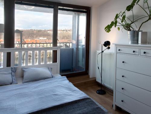 a bedroom with a bed and a large window at Cozy Apartment nearby Arena in Prague