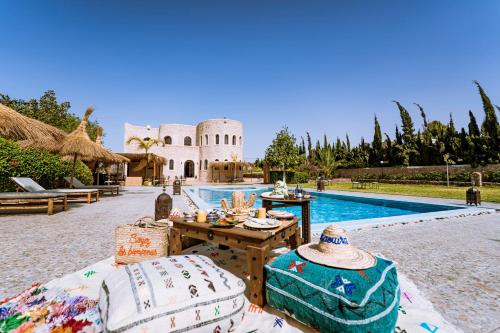 um pátio com uma mesa e cadeiras ao lado de uma piscina em RIAD YANITRI em Essaouira