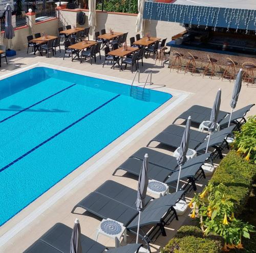 einen Pool mit Stühlen, einem Tisch und einem Pool in der Unterkunft Blue Heaven Apart Hotel in Alanya
