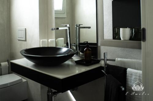 a bathroom with a black bowl sink on a counter at L'AmElie - Elegante Suite in Stra