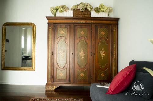 a large wooden cabinet in a living room with a mirror at L'AmElie - Elegante Suite in Stra