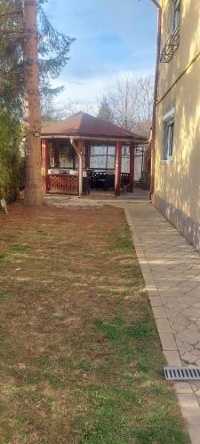 a building with a porch with a tree next to it at Casa Edan Breaza in Breaza