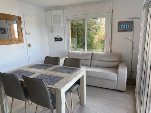 a living room with a table and a couch at Vue sur la baie de Sant Feliu de Guixols in Sant Feliu de Guíxols