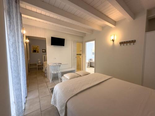 Schlafzimmer mit einem Bett, einem Tisch und einem TV in der Unterkunft Villa Nina - Apartments & Relax in Caprino Veronese