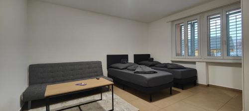sala de estar con 2 camas y sofá en Gästehaus Spring en Aarau