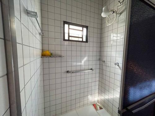 Campo Novo do ParecisにあるCasa confortável área centralの白いタイル張りのシャワーと窓付きのバスルーム