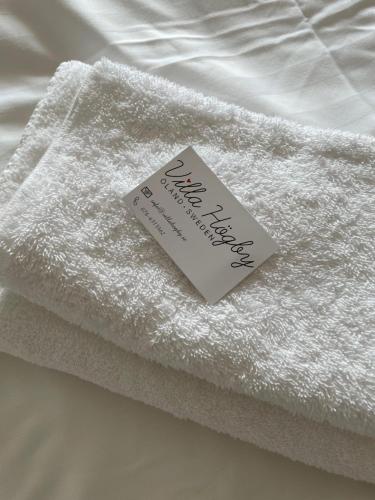 Löttorp的住宿－Villa Högby，床上有标志的白色毛巾