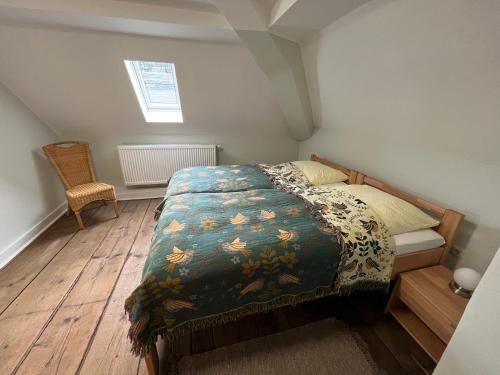 - une chambre avec un lit et une couverture dans l'établissement Ferienwohnung im ehemaligen Rittergut, à Wurzbach