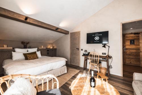 a bedroom with a bed and a desk in a room at Hôtel de la Roche in Beaufort