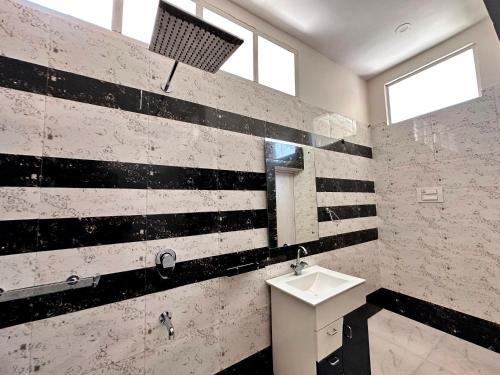 a bathroom with black and white stripes on the wall at Luxury Villa with Free Breakfast - RnR Manor in Kālka