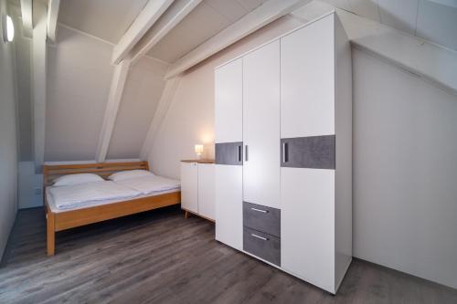 リプノ・ナト・ヴルタヴォウにあるApartmán Andy Riviera 503-10 Lipno Homeの小さなベッドルーム(ベッド1台、白いキャビネット付)