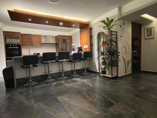 a kitchen with black bar stools in a room at Great apartment in the heart of Coyoacan in Mexico City