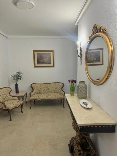 a living room with a couch and a mirror at El Paseíllo in Priego de Córdoba