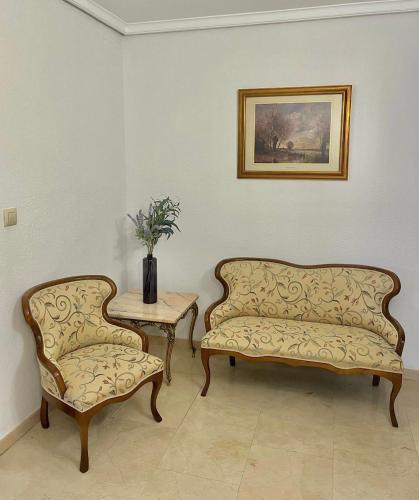 two couches and a table and a vase on a table at El Paseíllo in Priego de Córdoba