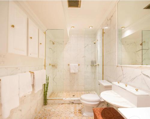a white bathroom with a toilet and a sink at TOWNHOUSE 222 in New York