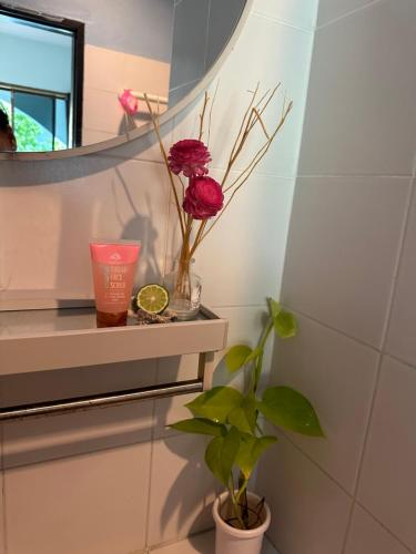 a bathroom with a shelf with flowers and a mirror at MILD ROOM SEA VIEW ROOM FOR RENT in Phi Phi Islands