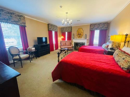 a hotel room with two beds and a television at Excelsior at the Manor House in Clemmons