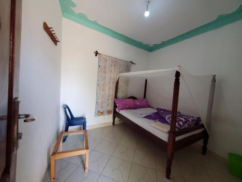 ein kleines Schlafzimmer mit einem Etagenbett und einem blauen Stuhl in der Unterkunft First Mayor' Garden in Malamagambo
