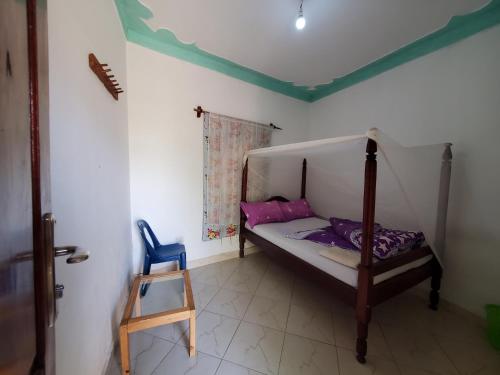 ein kleines Schlafzimmer mit einem Bett und einem Stuhl in der Unterkunft First Mayor' Garden in Malamagambo