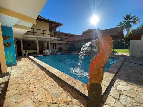 a statue of a woman standing next to a swimming pool at Pousada Lua Cheia in Japaratinga