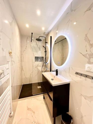 une salle de bain blanche avec un lavabo et un miroir dans l'établissement Barcaresa-Brillant appartement vue mer piscine, au Barcarès