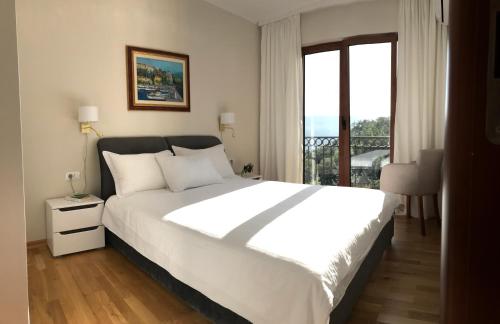 ein Schlafzimmer mit einem großen weißen Bett und einem Fenster in der Unterkunft Adria Montenegro Seaview in Herceg-Novi