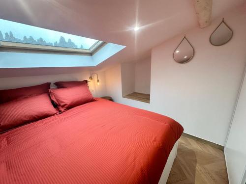 - une chambre avec un lit rouge et une fenêtre dans l'établissement Elegant mansardé-place du pin, à Nice