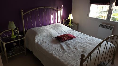 - un lit avec un oreiller rouge dans la chambre dans l'établissement appartement frejus plage, à Fréjus