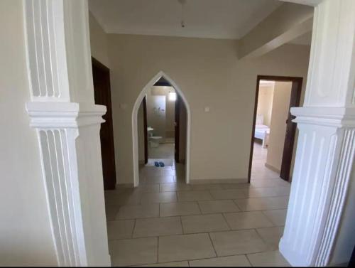 a hallway with white columns and a hallway with a mirror at deep east in Ruiru