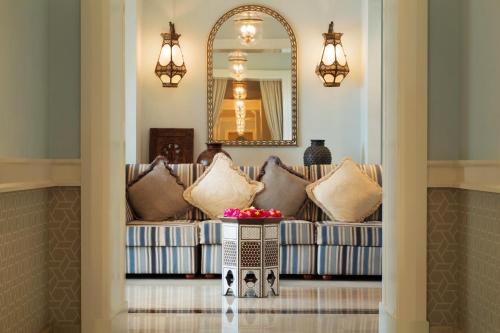 a living room with a couch and a mirror at Djibouti Palace Kempinski in Djibouti