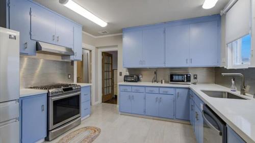 a large kitchen with blue cabinets and appliances at Come experience the Sunsets ! in San Francisco