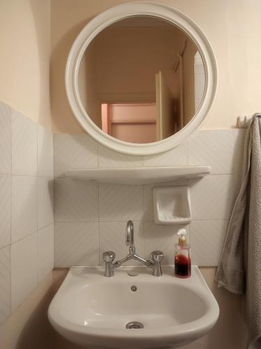 een badkamer met een wastafel en een spiegel bij Mema's Tranquil Studio in Patra - Free Parking in Patra