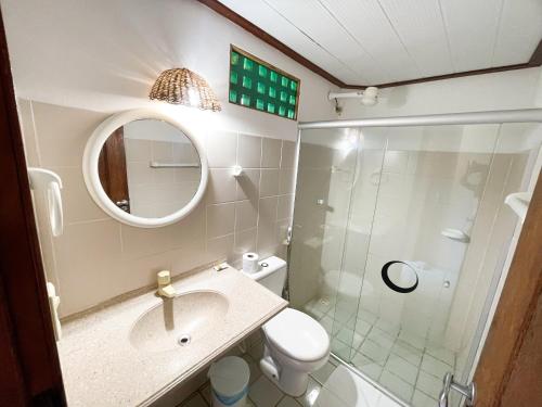 a bathroom with a toilet and a sink and a shower at Pousada Lua Cheia in Japaratinga