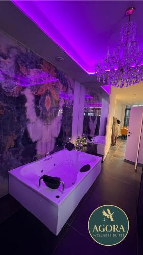 a large bath tub in a room with purple lighting at AGORA Tournai Wellness Suites Grand-Place in Tournai