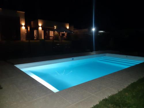 a swimming pool lit up at night at Hermosa casa en barrio privado de 2 habitaciones in Concepción del Uruguay