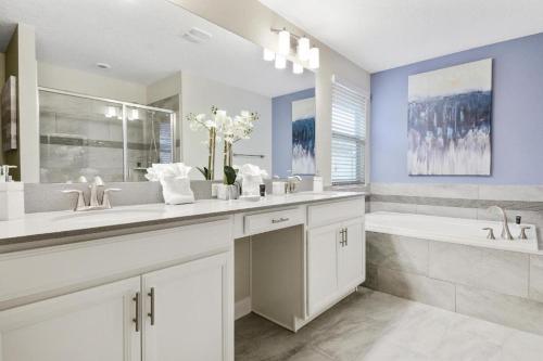 a white bathroom with two sinks and a tub at Wonderful Villas 18 Minutes away from Disney! in Kissimmee